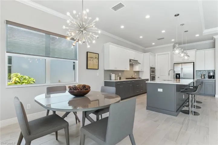 Dining area with visible vents, baseboards, a notable chandelier, and ornamental molding
