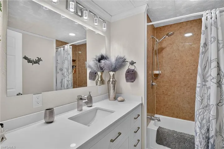 White vanity with an integrated rectangular sink, single-handle faucet, and polished hardware