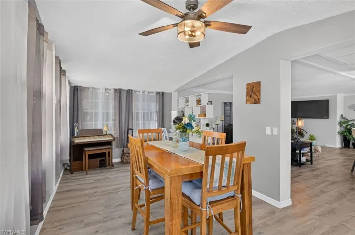 Spacious interior with wood-finish flooring, a ceiling fan, and multiple windows