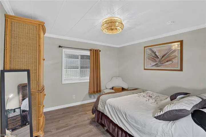 Guest Bedroom Recessed lighting and wood-finish flooring complement the room