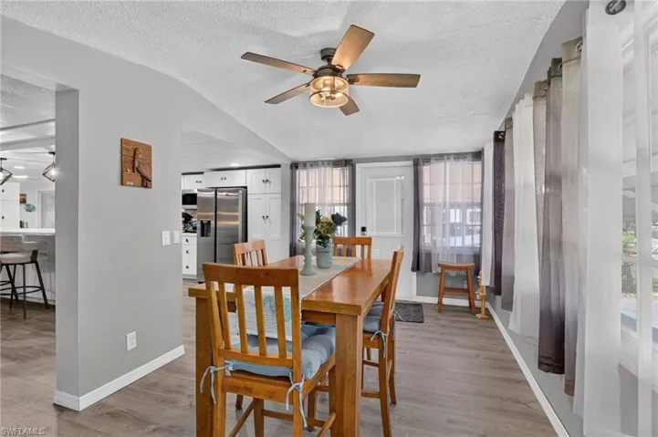 Wood-finish flooring, vaulted ceiling, and an attached ceiling fan