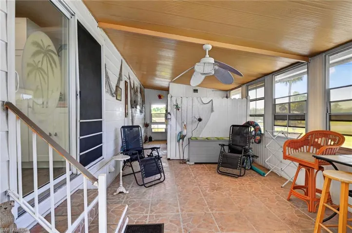 Enclosed porch with a wood-finish ceiling, ceiling fan, multiple windows, and a tiled floor