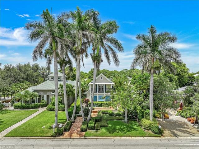 Front of enchanting, elevated home, w/ over 2800 sq ft under AC-over 4100 sq ft total area, features several Royal Palms, manicured landscaping, brick walkways, privacy shutters plus 2nd level balcony!