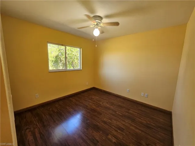 Spare room featuring ceiling fan and dark hardwood / wood-style floors