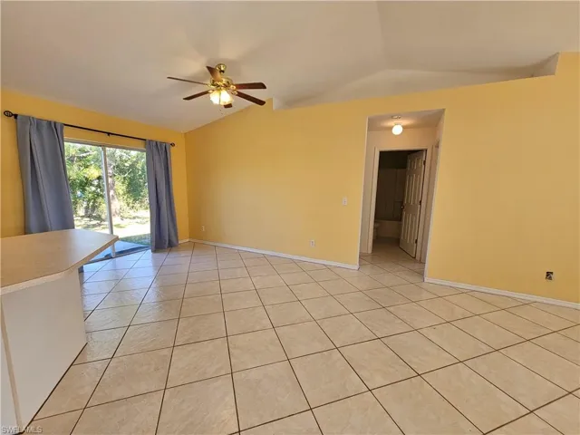 Tiled spare room with ceiling fan and lofted ceiling