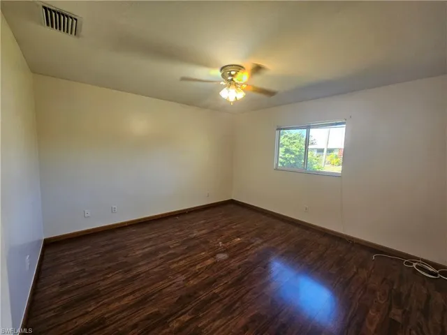 Empty room with ceiling fan and hardwood / wood-style floors