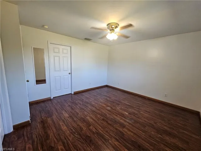 Spare room featuring ceiling fan and dark hardwood / wood-style floors