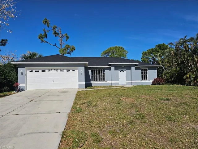 Ranch-style house with a front yard and a garage