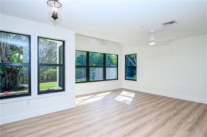 Empty room with ceiling fan and light hardwood / wood-style flooring