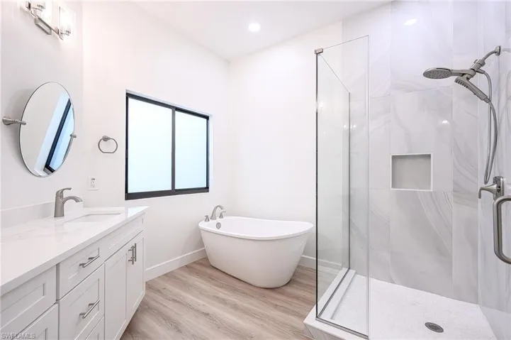Master Bath with hardwood / wood-style flooring, vanity, and shower with separate bathtub