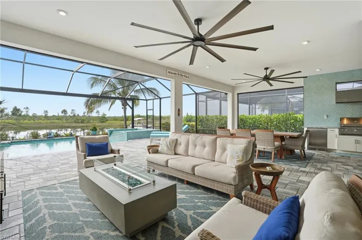 View of patio featuring an outdoor pool, ceiling fan, an outdoor living space with a fire pit, and outdoor dining area