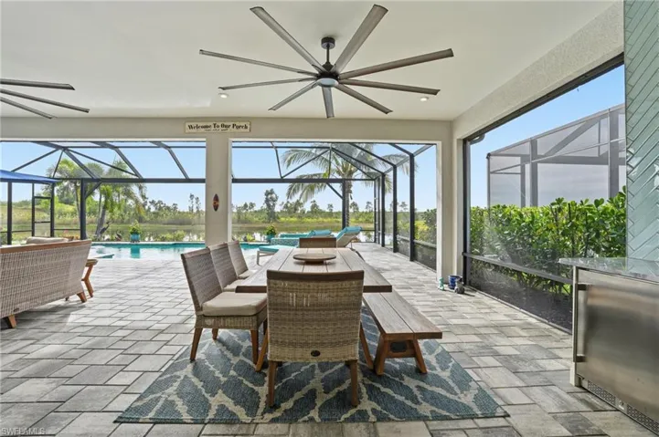 View of patio / terrace featuring a ceiling fan, a lanai, a sunroom, and an outdoor pool