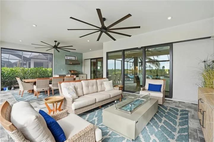 Living area with a sunroom, recessed lighting, an accent wall, and a ceiling fan