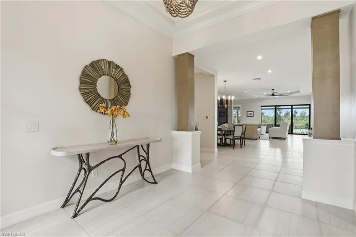 Corridor with recessed lighting, a chandelier, and light tile patterned floors