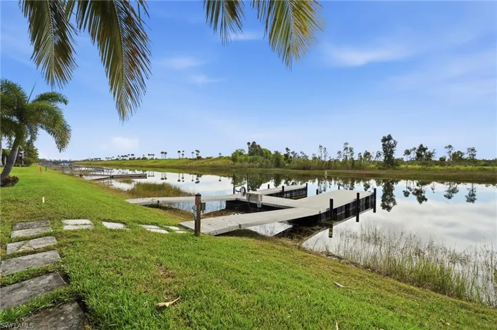 Dock with a water view and a lawn