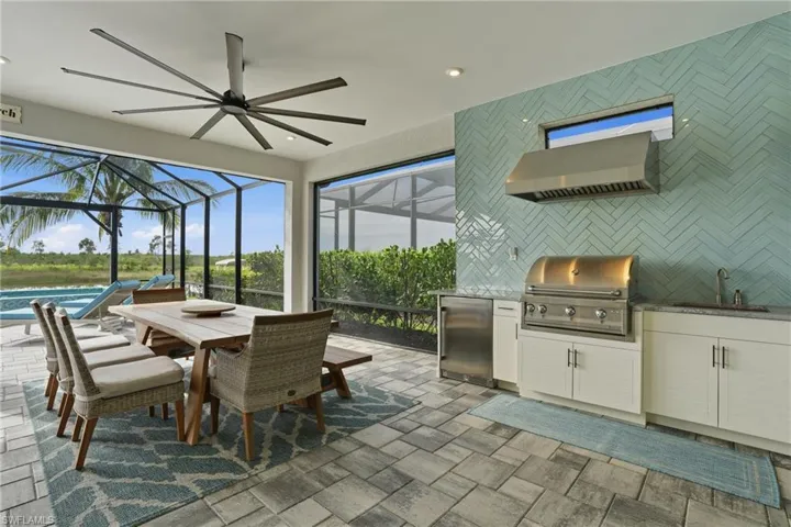 View of patio / terrace with glass enclosure, outdoor dining space, exterior kitchen, and a sunroom