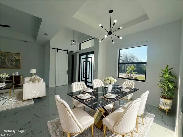 Virtually staging Dining space featuring marble finish floor, a barn door, a raised ceiling, and visible vents