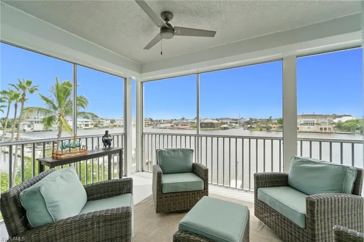 Sunroom with ceiling fan, a balcony, a water view, and outdoor lounge area