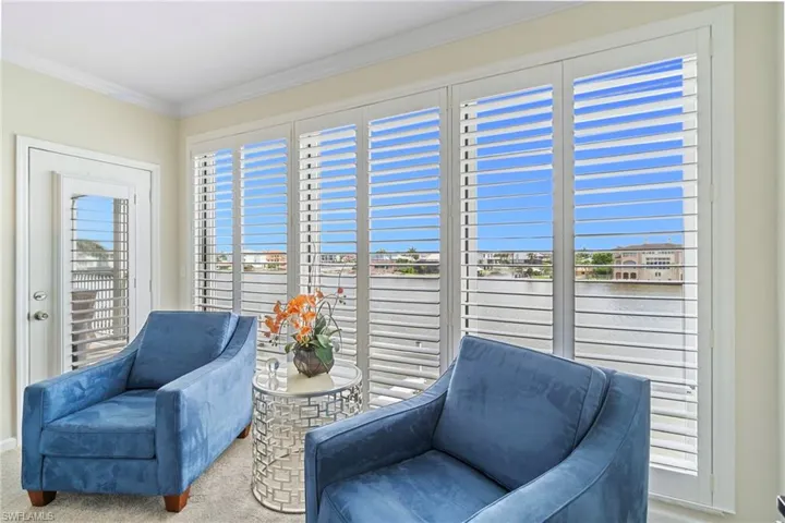 Sitting room with ornamental molding, a water view, and carpet floors