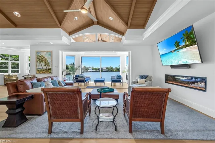 Living room with healthy amount of natural light, high vaulted ceiling, a ceiling fan, recessed lighting, and a wooden ceiling with exposed beams