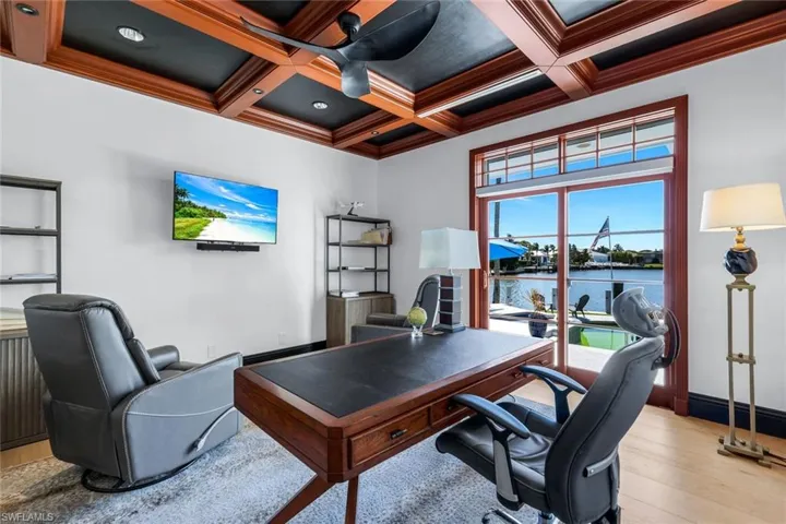 Office area featuring light wood finished floors, coffered ceiling, beam ceiling, and crown molding