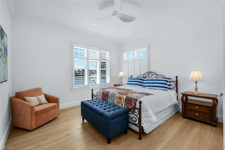 Bedroom featuring ornamental molding, light wood-style flooring, and ceiling fan