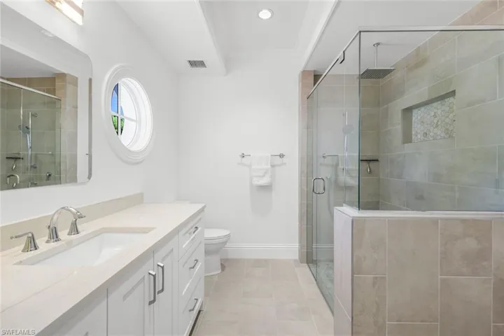 Bathroom with vanity, a stall shower, light tile patterned flooring, ornamental molding, and recessed lighting