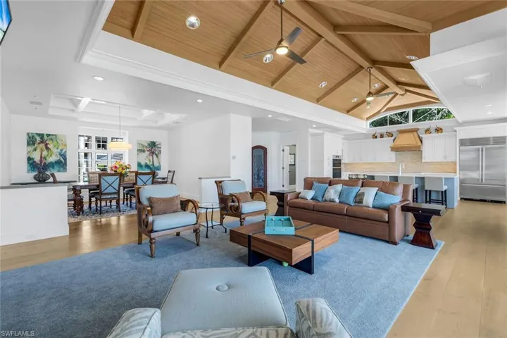 Living room featuring light wood-style floors, high vaulted ceiling, recessed lighting, a ceiling fan, and a wood ceiling with exposed beams