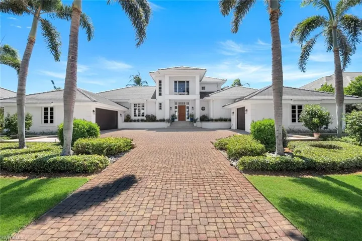 View of front facade featuring an attached garage, decorative driveway, stucco siding, and a front yard