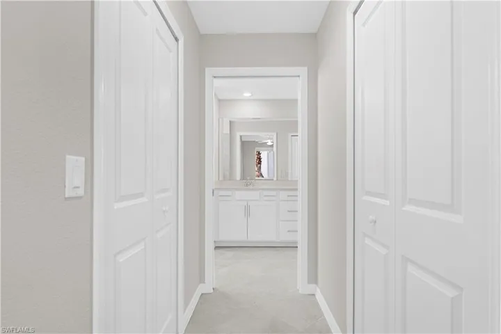 Hallway featuring bi-fold doors, light gray wall paint, and recessed lighting