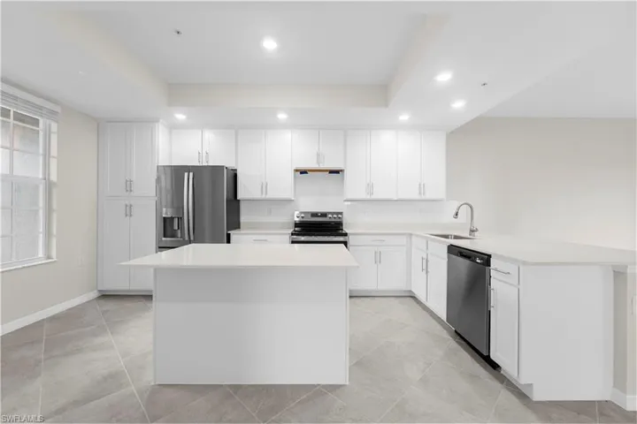 Contemporary kitchen featuring white cabinetry, a center island, stainless steel appliances, and recessed lighting