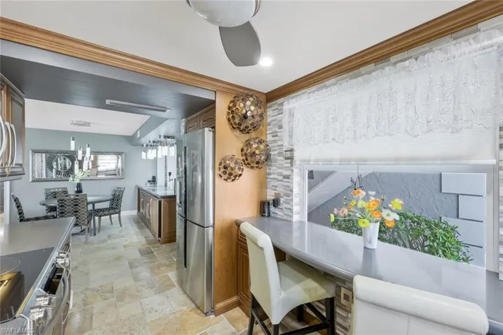 Dining area featuring stone tile floors, crown molding, and baseboards