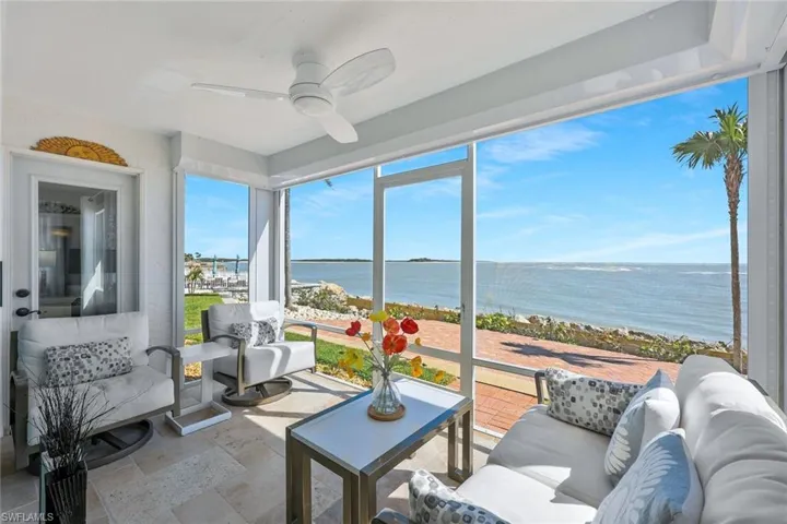 Sunroom featuring a ceiling fan and a water view