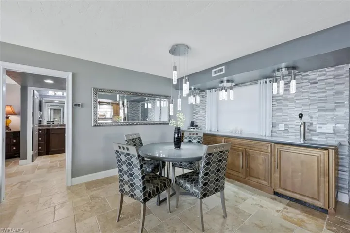 Dining space with visible vents, baseboards, and stone tile floors