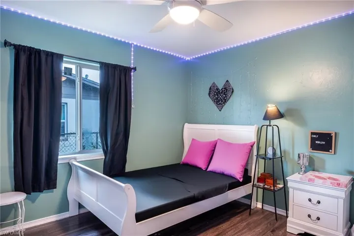 Bedroom with ceiling fan and dark wood-type flooring