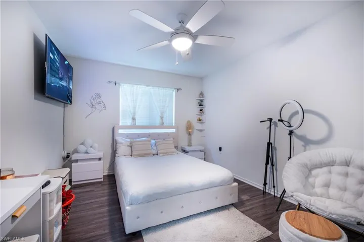 Bedroom with dark hardwood / wood-style floors and ceiling fan
