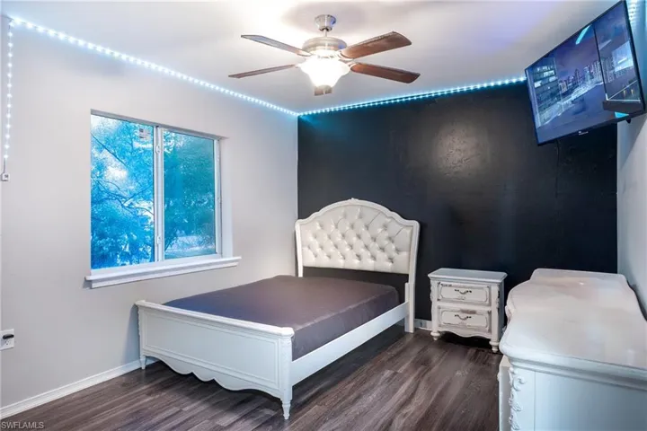 Bedroom with dark hardwood / wood-style floors and ceiling fan