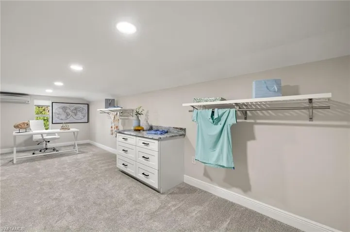 Large walk-in closet with carpet and an AC wall unit
