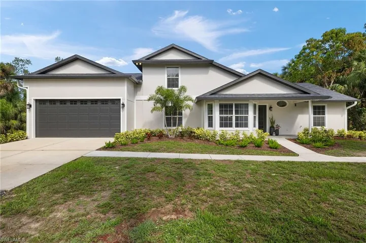 View of front of house featuring siding, an attached garage, a front lawn, and concrete driveway