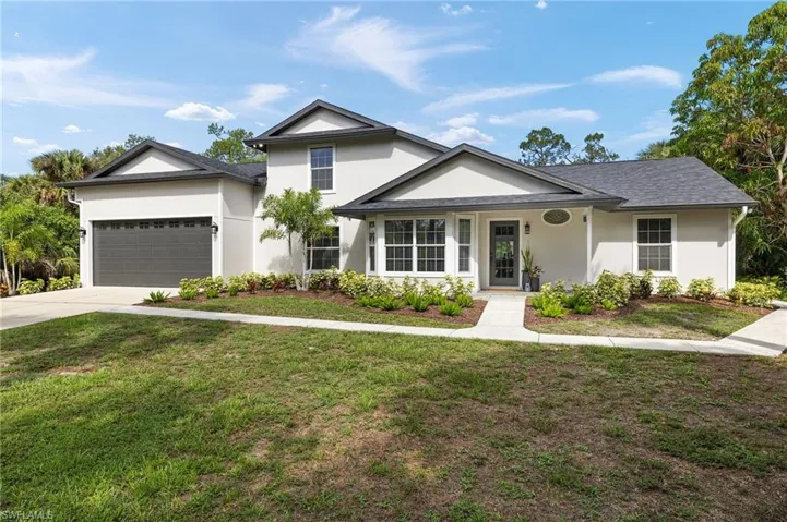 View of front of property with siding, a front lawn, and a garage