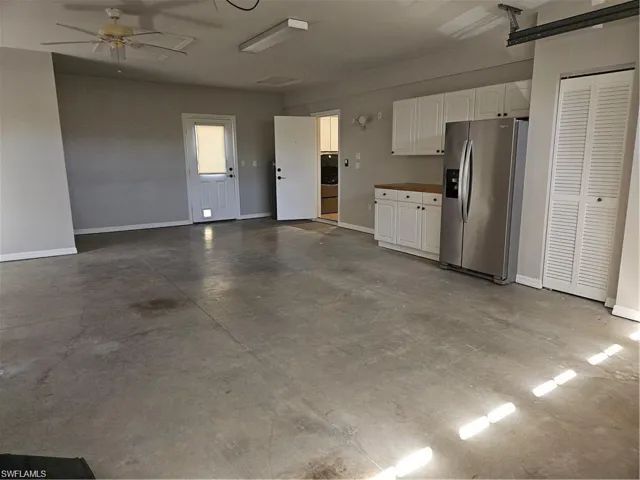 Garage featuring stainless steel fridge, washer / clothes dryer, and ceiling fan