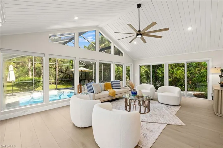 Sunroom featuring healthy amount of natural light, wood finished floors, high vaulted ceiling, and wooden ceiling