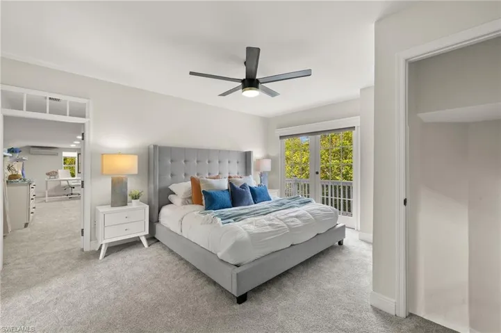 Master bedroom, carpeted with access to balcony, and a ceiling fan