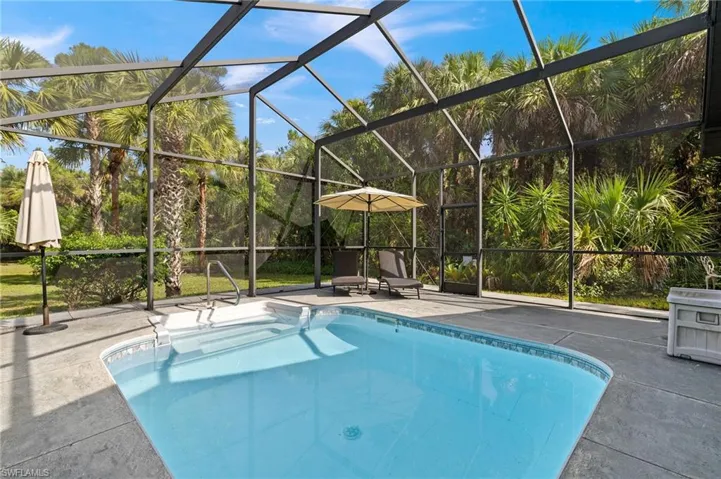 Swimming pool with screened enclosure and a patio area