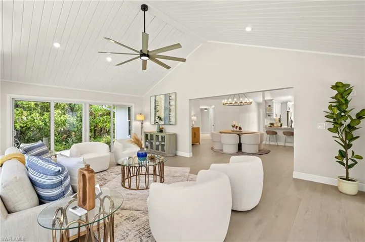 Living room featuring high vaulted ceiling, ceiling fan, light wood finished floors, and recessed lighting