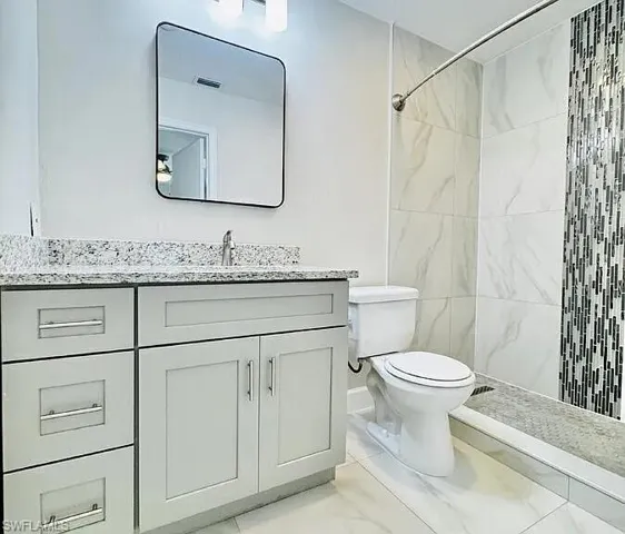 Vanity with a light-toned countertop, rectangular sink, and cabinet storage