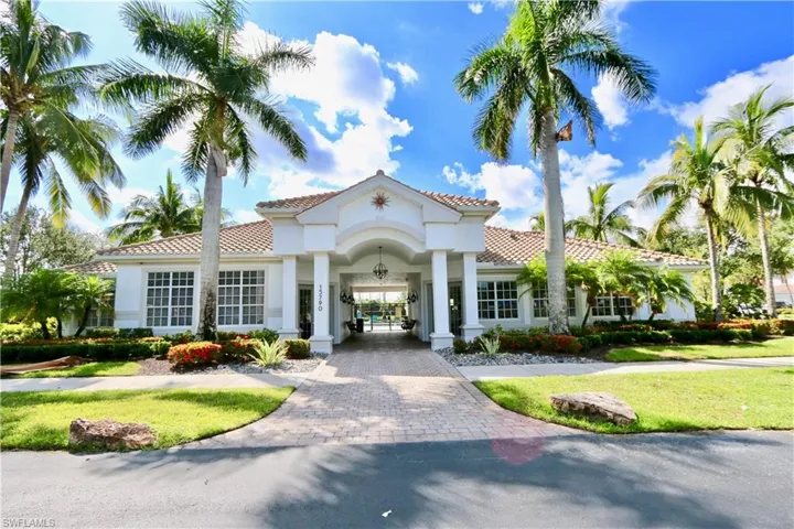 Stately entrance featuring a covered portico, arched entryway, and dual hanging light fixtures
