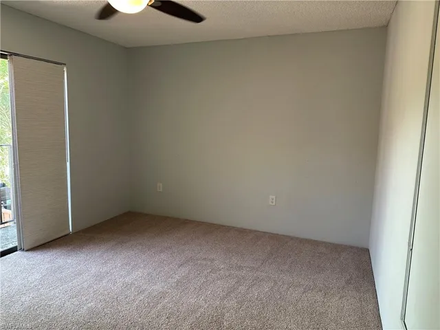 Carpeted empty room with a ceiling fan