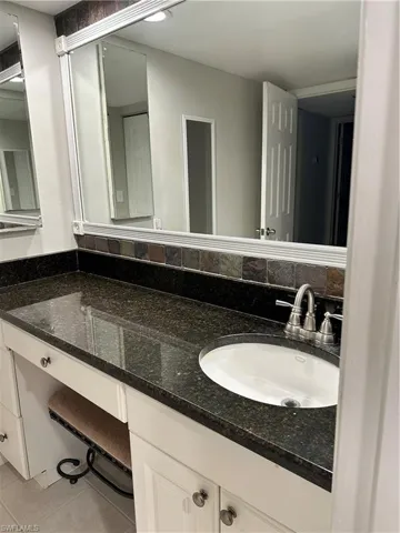 Bathroom with double vanity and tile patterned flooring