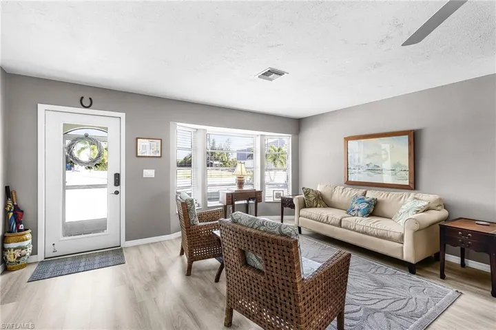 Living room has a bay window, and there is a screened porch at the entry.